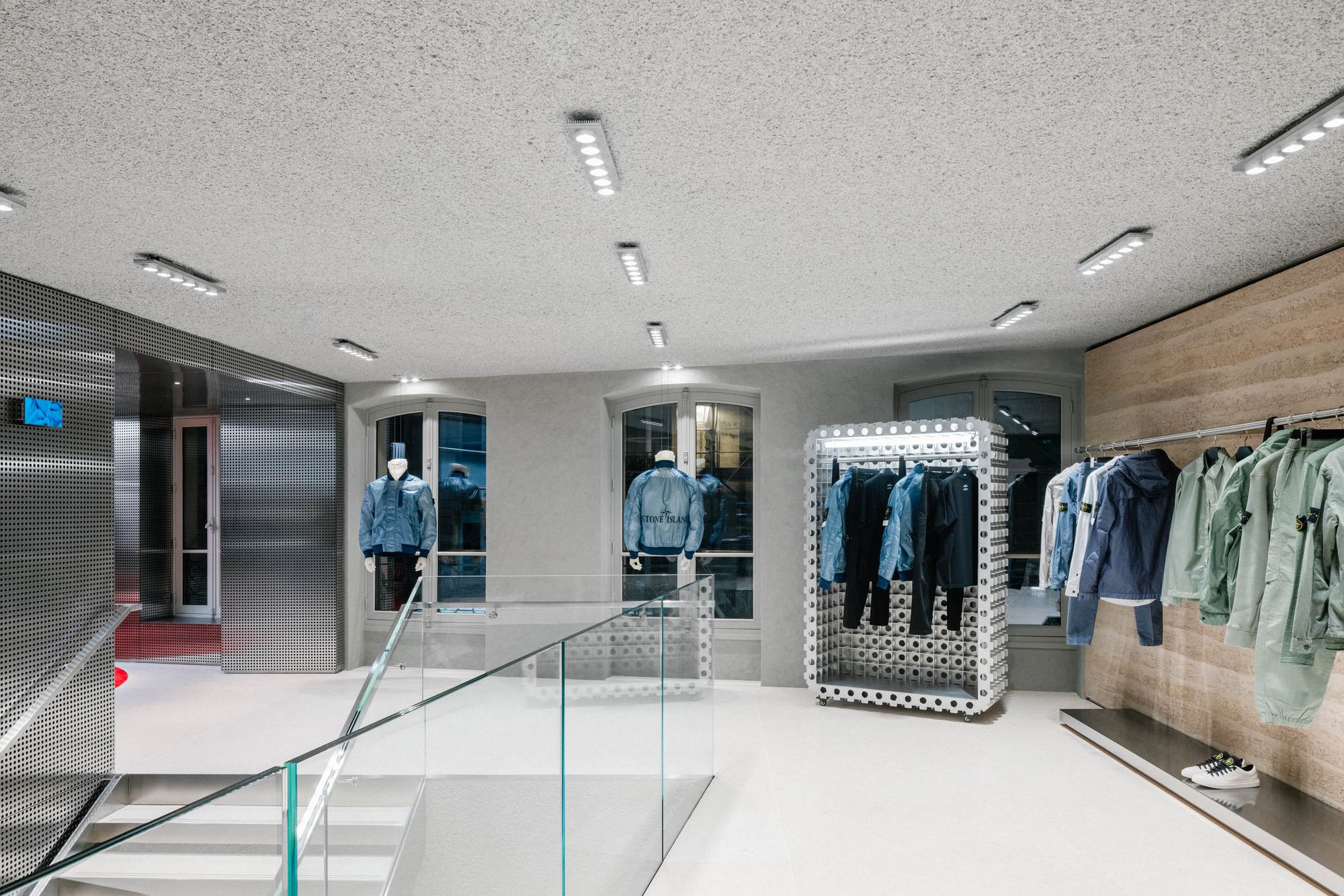 Espace de vente sur deux niveaux avec plafond acoustique projeté blanc à grain fin, configuration de teinte standard la moins coûteuse